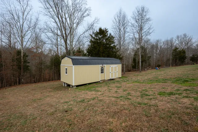 a view of a barn in the middle of a yard