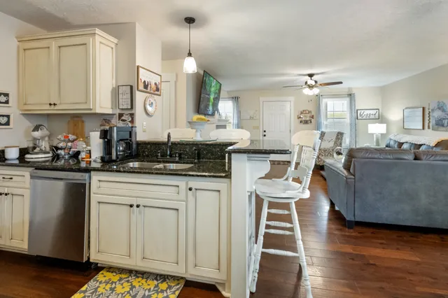 a open kitchen with white cabinets and wooden floor