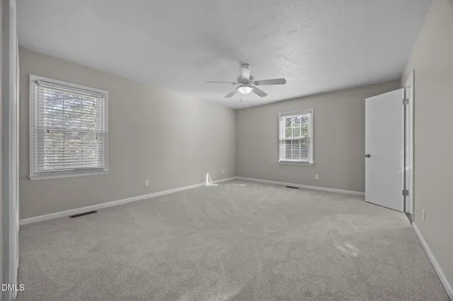 a view of an empty room with a ceiling fan
