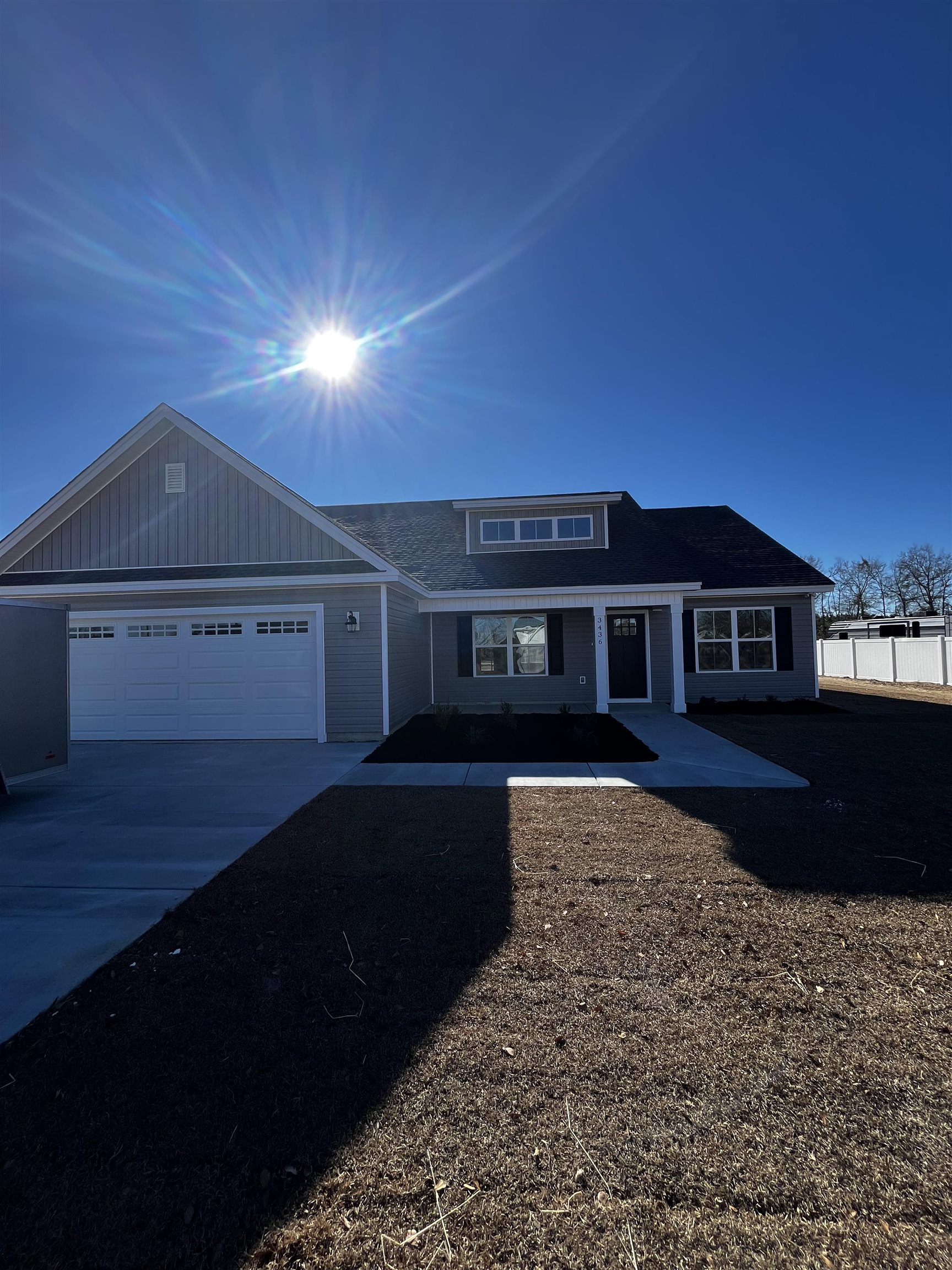 View of front of home with driveway, an attached garage, and a porch