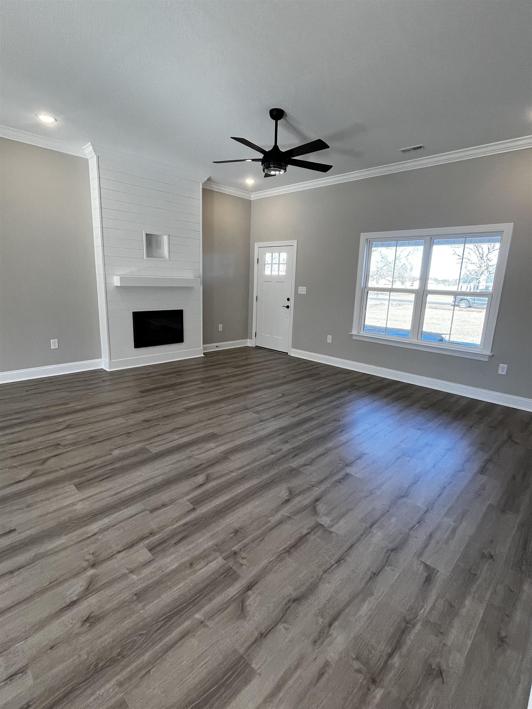3436 Asbury Road Aynor, SC 29511 - Photo 3 of 9 Unfurnished living room featuring ornamental molding, a fireplace, dark wood-style floors, and ceiling fan
