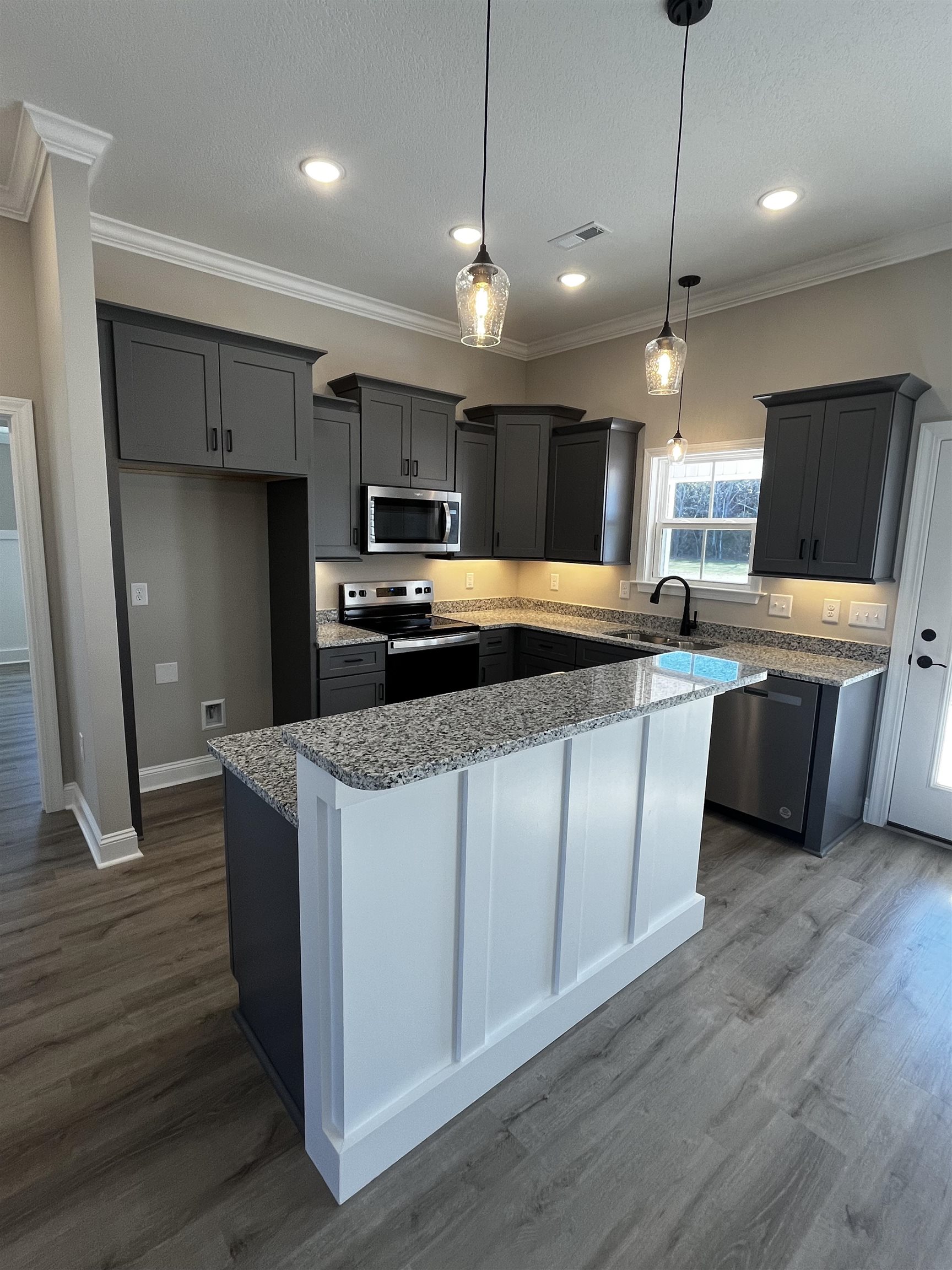 3436 Asbury Road Aynor, SC 29511 - Photo 4 of 9 Kitchen featuring ornamental molding, appliances with stainless steel finishes, light stone countertops, decorative light fixtures, and a center island