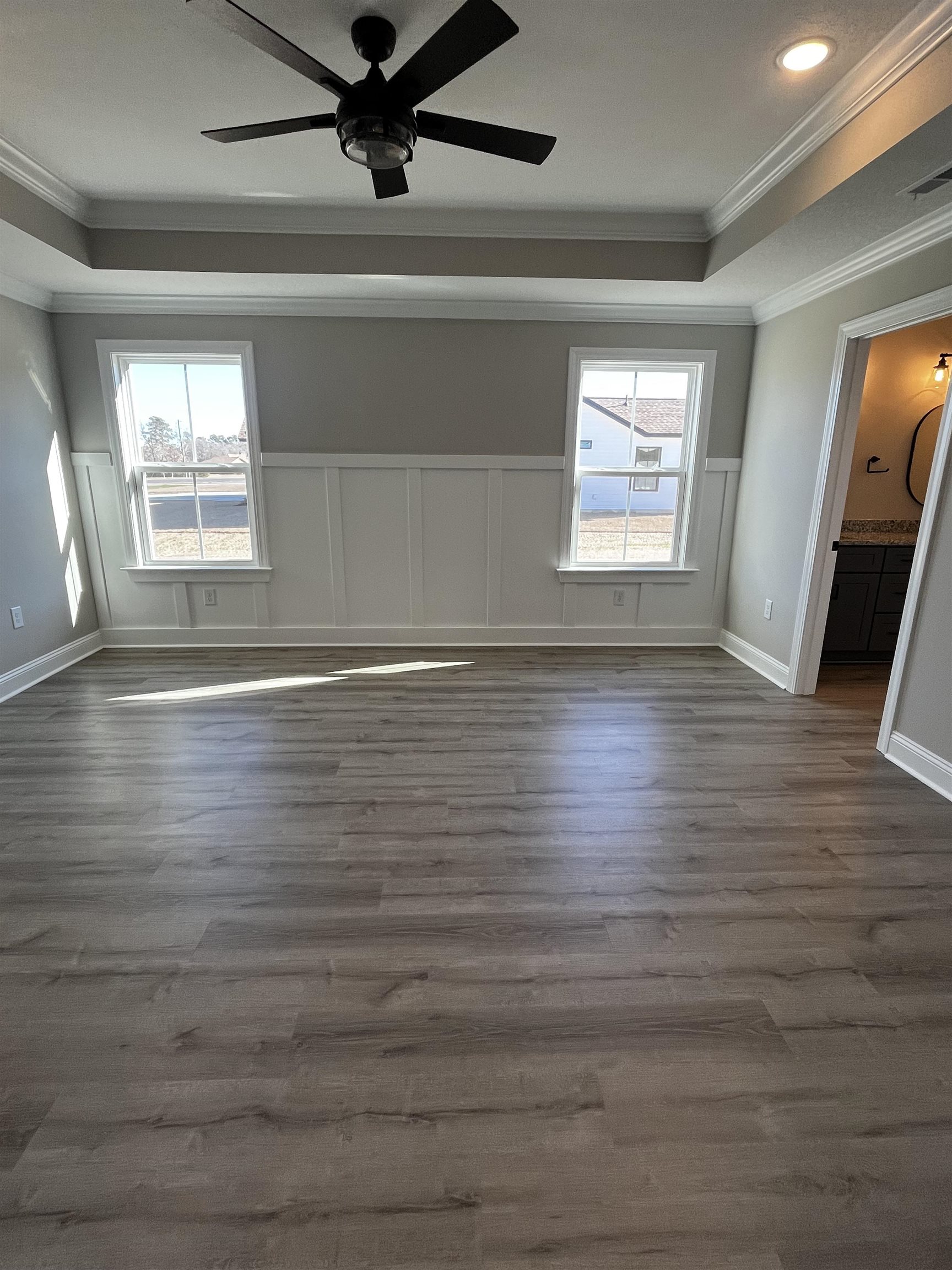 3436 Asbury Road Aynor, SC 29511 - Photo 5 of 9 Unfurnished bedroom with a tray ceiling, ornamental molding, dark wood-style flooring, ceiling fan, and multiple windows
