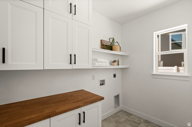 14728 South Canyon Pointe Road Draper, UT 84020 - Photo 13 of 35 Laundry area featuring extensive white shaker cabinetry, a wood-finish countertop, floating shelves, and a window for natural light