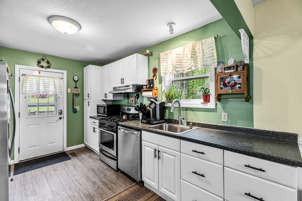 302 Middlefield Road Chester, MA 01011 - Photo 5 of 42 a kitchen with stainless steel appliances granite countertop a sink a stove and a window