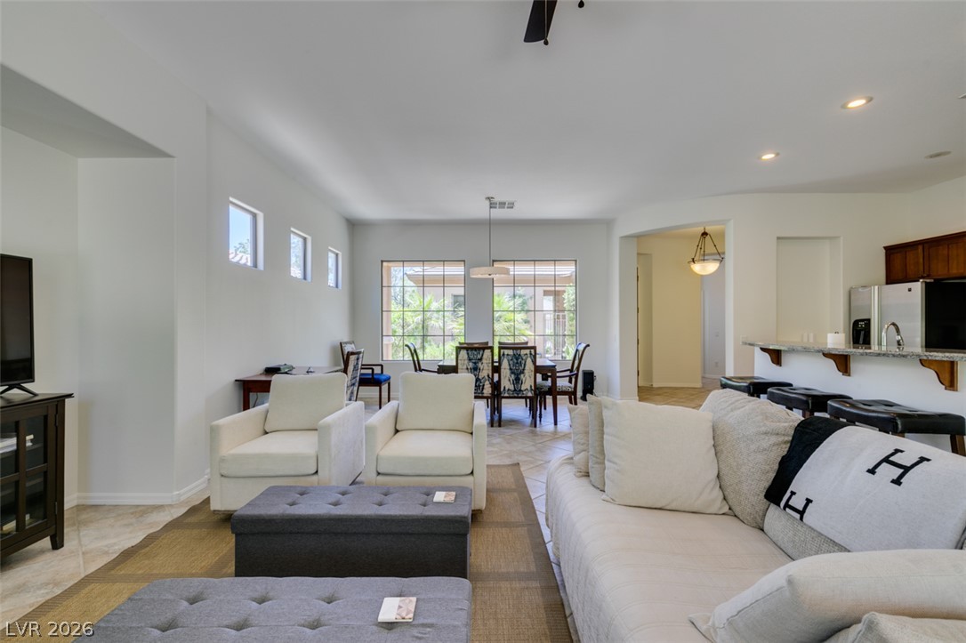 8 Kennesaw Road Henderson, NV 89052 - Photo 18 of 44 An open concept living area features ample seating, seamlessly flowing into a dining space with abundant natural light.