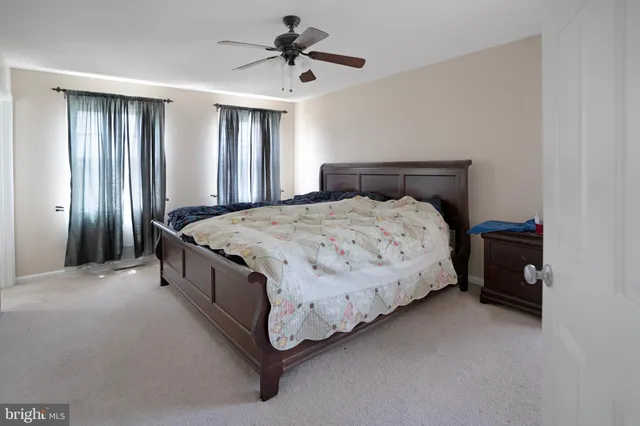 a spacious bedroom with a bed and a chandelier