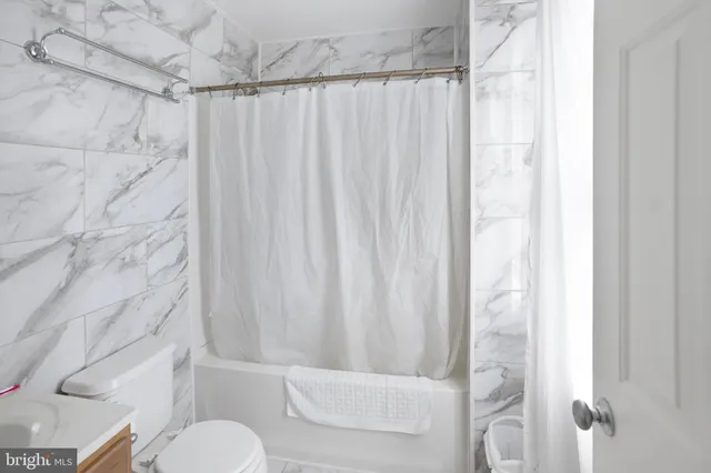 a white toilet sitting next to a shower curtain