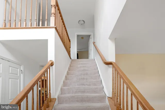 a view of staircase with lots of frames on wall and wooden floor