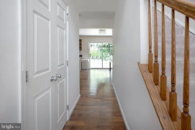 a view of a hallway with wooden floor and staircase