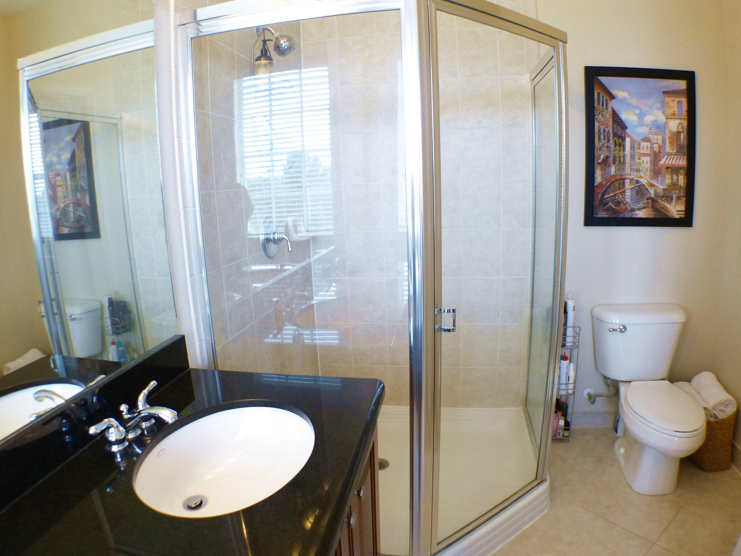 1826 Northwest 9th Street Boca Raton, FL 33431 - Photo 17 of 22 a bathroom with a toilet a sink and a mirror