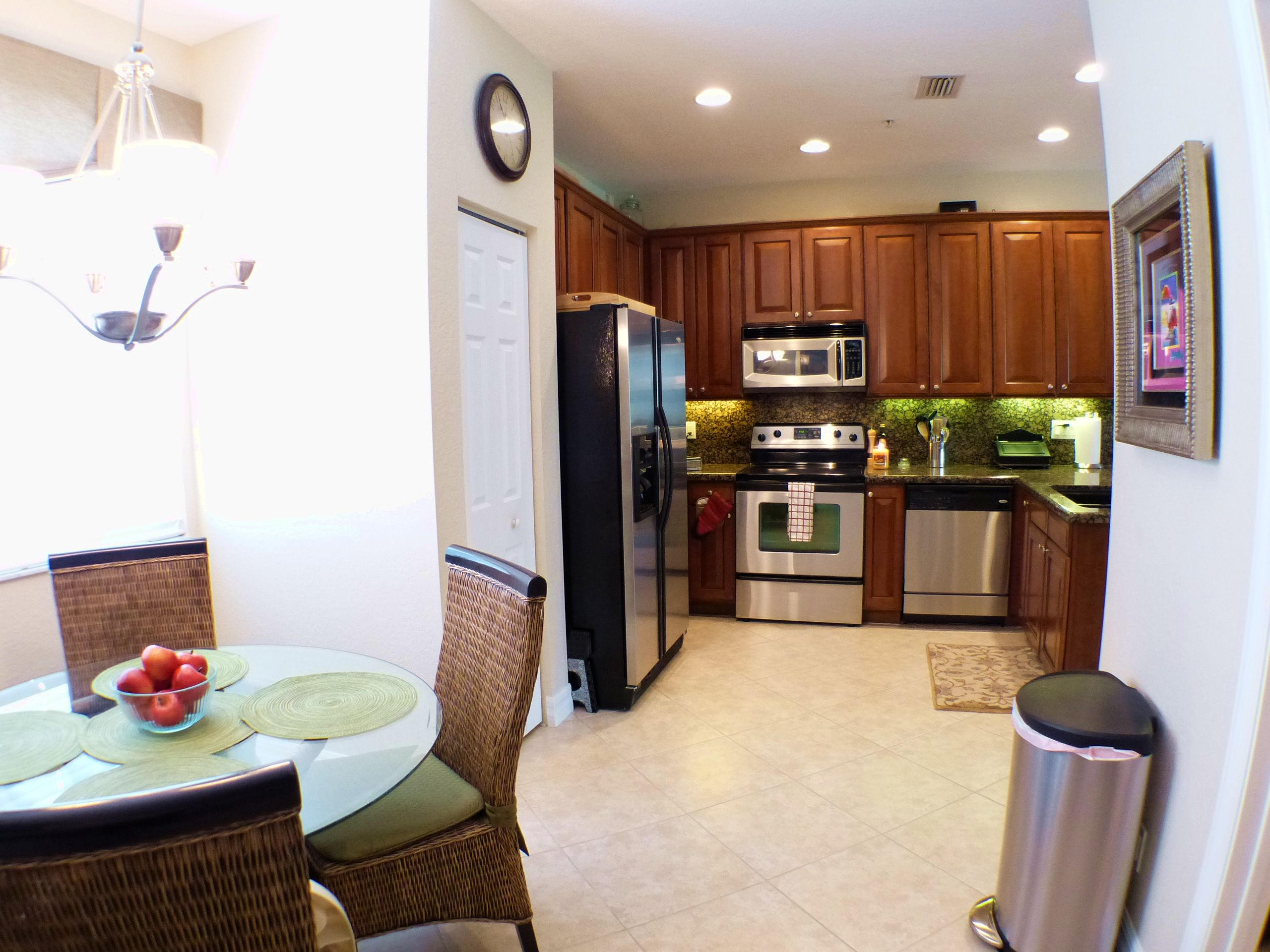 1826 Northwest 9th Street Boca Raton, FL 33431 - Photo 10 of 22 a kitchen with stainless steel appliances kitchen island granite countertop a refrigerator and a stove top oven