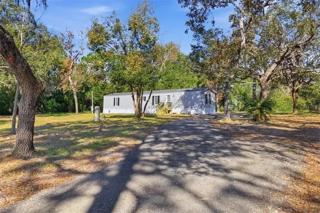 a view of a house with yard and tree s