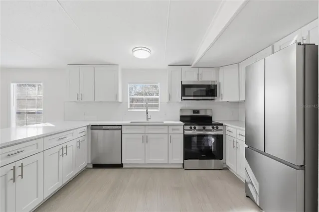 a kitchen with white cabinets and stainless steel appliances