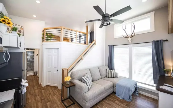 a living room with furniture a ceiling fan and a window