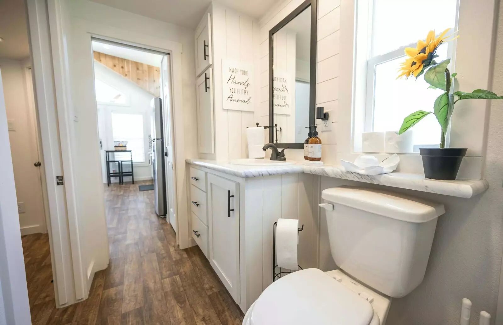 5386 Ranch Road 1376, Unit 79 Fredericksburg, TX 78624 - Photo 10 of 39 Half bathroom with dark wood-style flooring, vanity, and healthy amount of natural light
