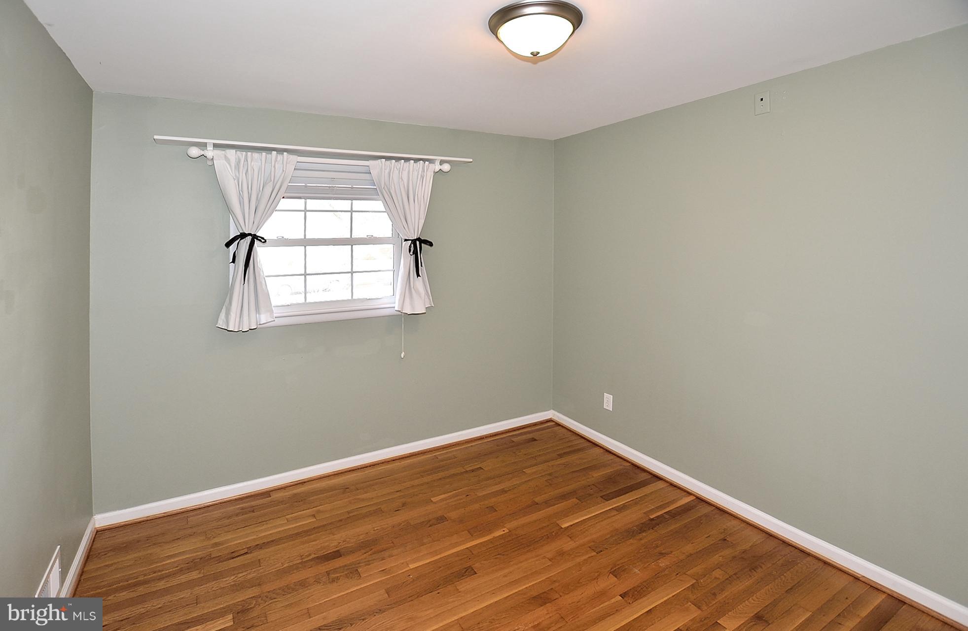 506 Tapawingo Road Southwest Vienna, VA 22180 - Photo 15 of 25 an empty room with wooden floor and windows