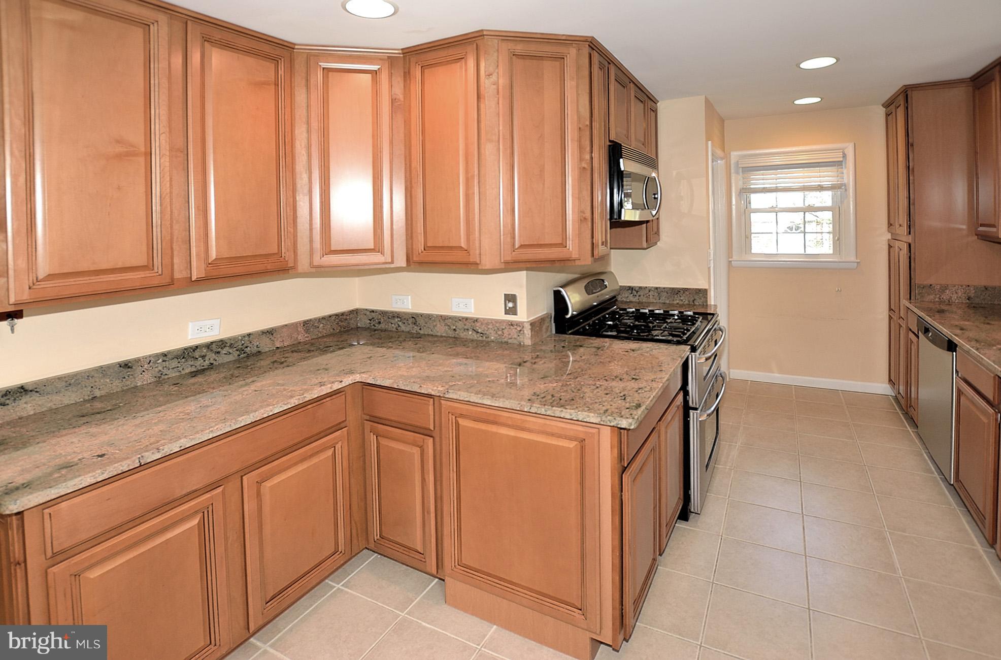 506 Tapawingo Road Southwest Vienna, VA 22180 - Photo 8 of 25 a kitchen with a stove a sink and a cabinets