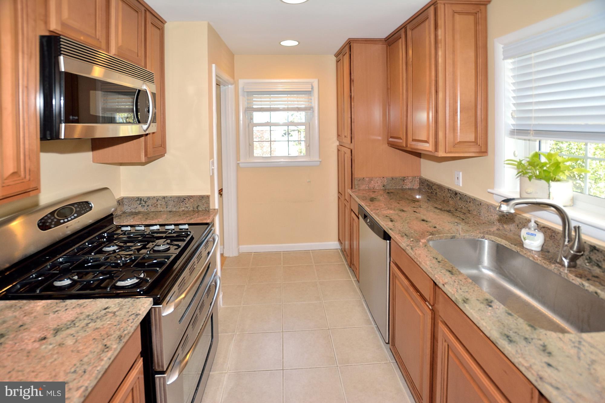 506 Tapawingo Road Southwest Vienna, VA 22180 - Photo 9 of 25 a kitchen with stainless steel appliances granite countertop a stove a sink and a microwave