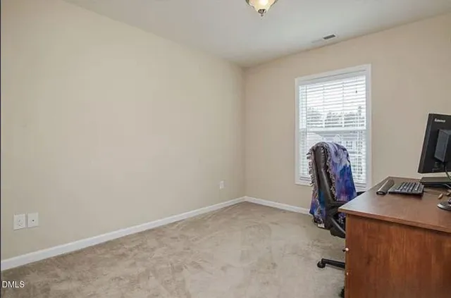 a view of a workspace with furniture and a window