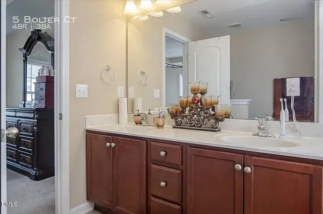 a bathroom with a granite countertop sink vanity and mirror