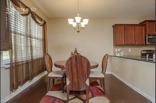 a view of a dining room with furniture a chandelier and wooden floor
