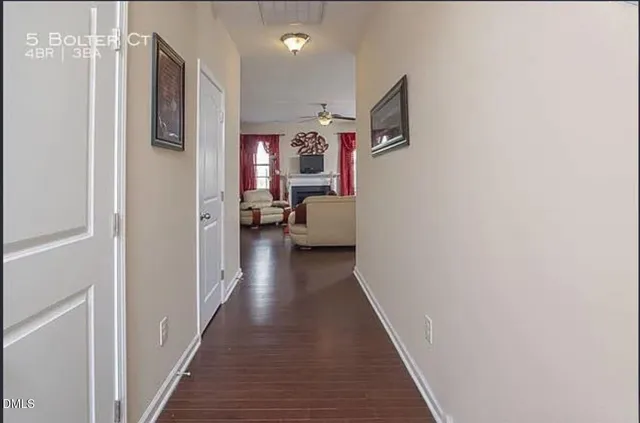 a view of a hallway with wooden floor and staircase