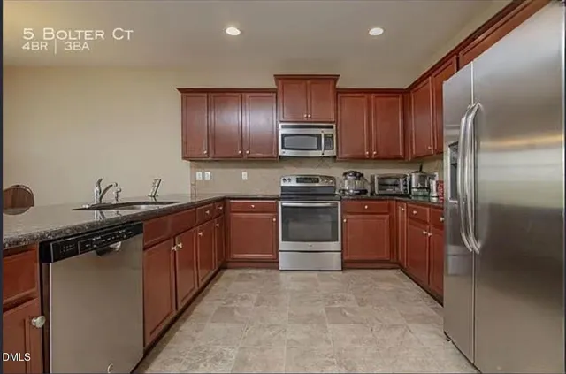 a kitchen with stainless steel appliances granite countertop a stove refrigerator sink and cabinets