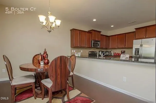 a kitchen with a dining table chairs and a refrigerator