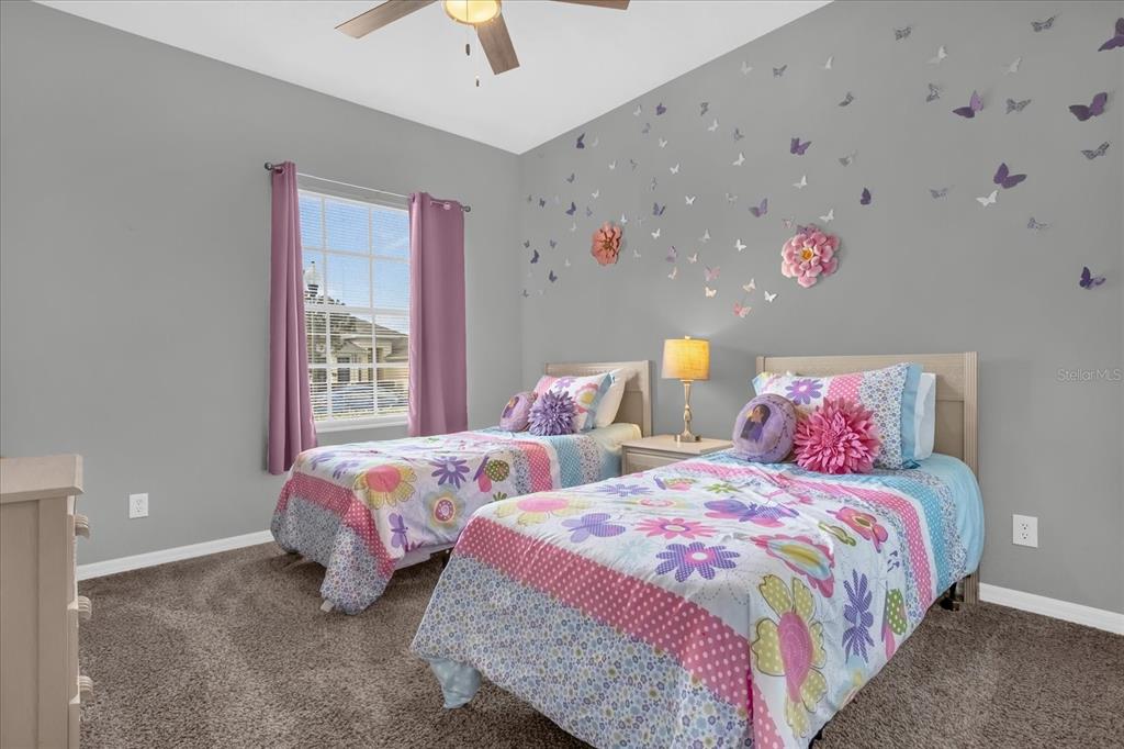 246 Montara Drive Davenport, FL 33897 - Photo 14 of 37 a bedroom with two beds and a chandelier