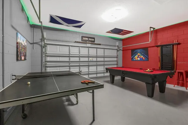 a room with pool table and windows