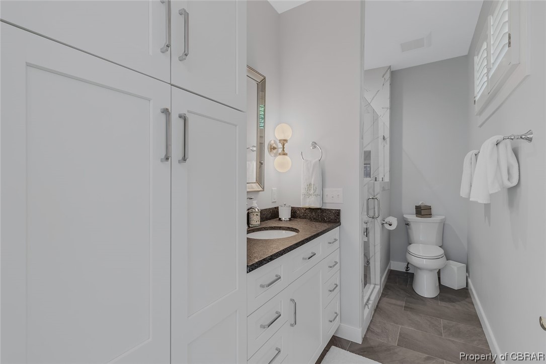 192 Bayberry Point Lane Kilmarnock, VA 22482 - Photo 44 of 49 Bathroom with a wealth of natural light, vanity, mirror, and dark tile floors