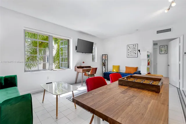 a living room with furniture a flat screen tv and a large window