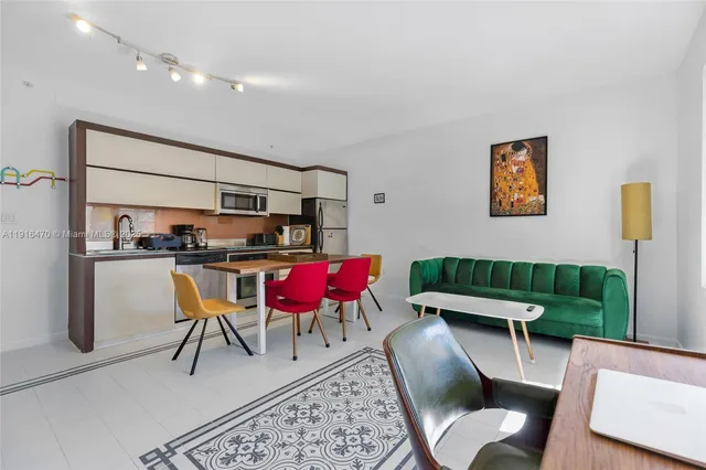 a living room with furniture a rug and kitchen view