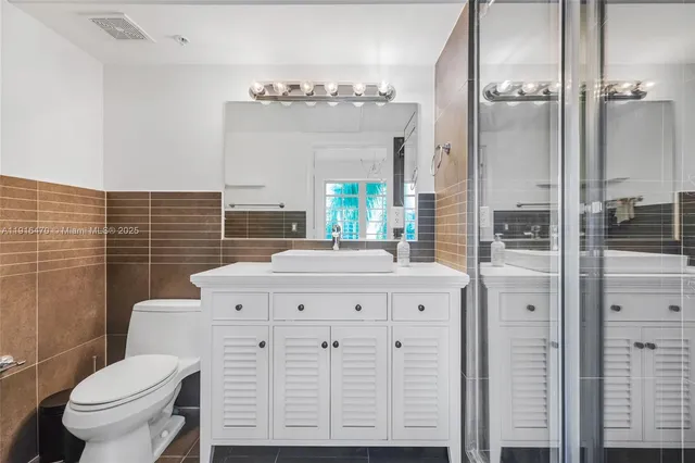 a bathroom with a double vanity sink mirror and shower