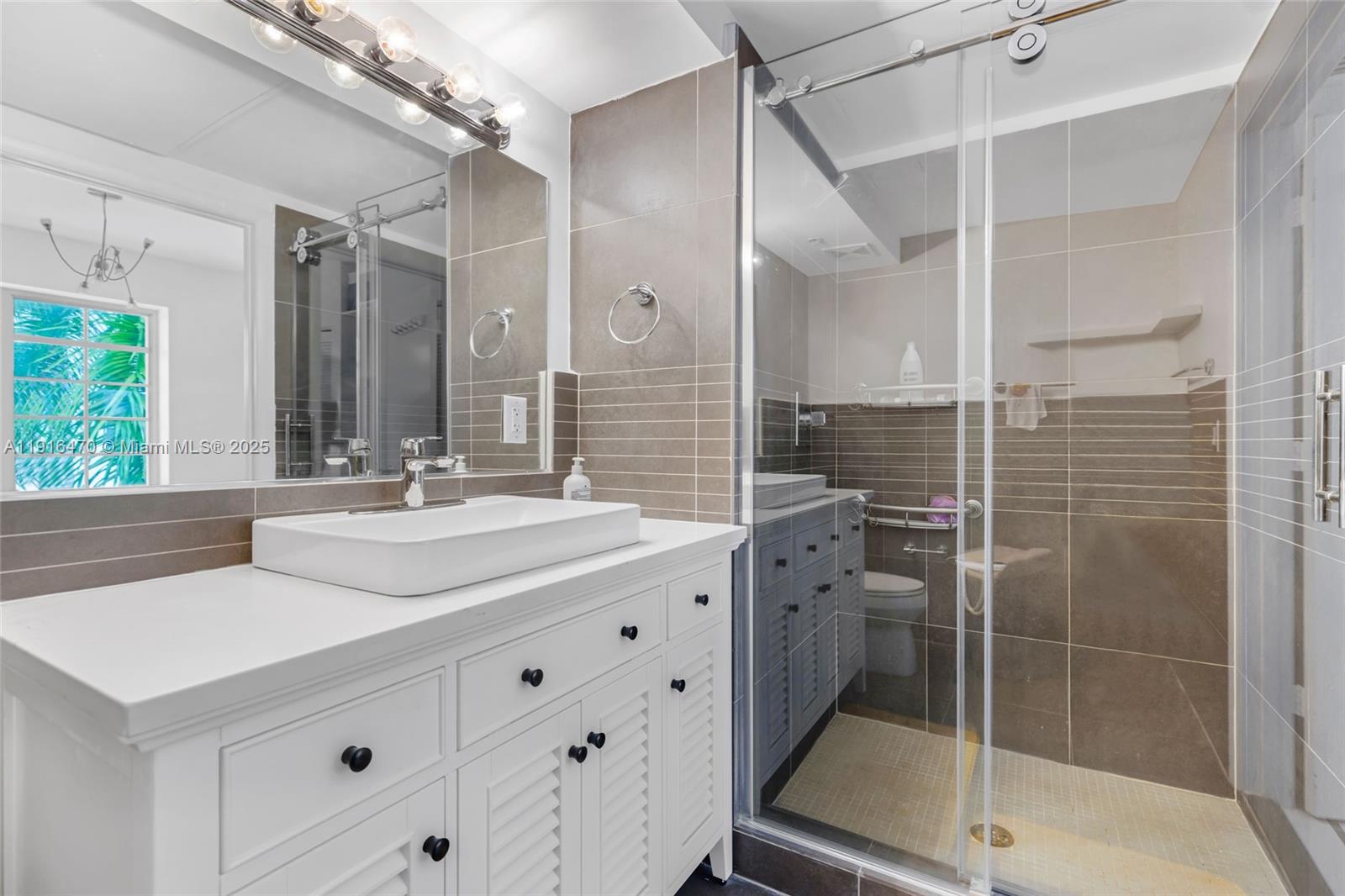 435 21st Street, Unit 311 Miami Beach, FL 33139 - Photo 31 of 40 a bathroom with a double vanity sink mirror and shower