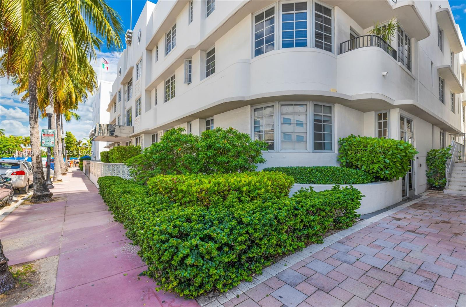 435 21st Street, Unit 311 Miami Beach, FL 33139 - Photo 39 of 40 a front view of a multi story residential apartment building with yard and bench