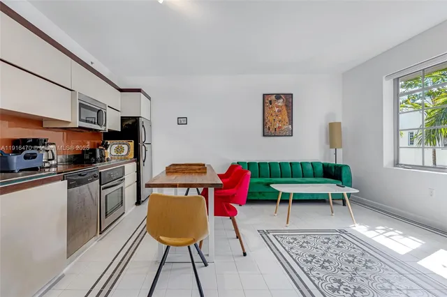 a kitchen with a dining table chairs and a refrigerator