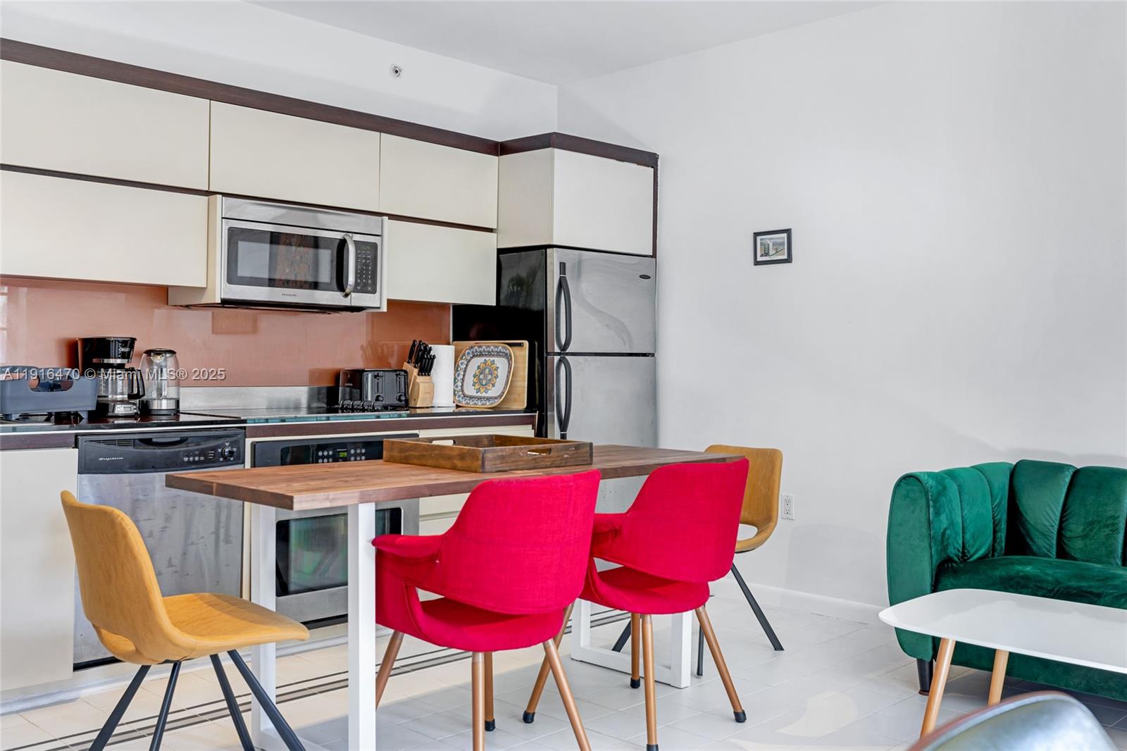 435 21st Street, Unit 311 Miami Beach, FL 33139 - Photo 10 of 40 a kitchen with stainless steel appliances granite countertop a dining table chairs refrigerator and sink