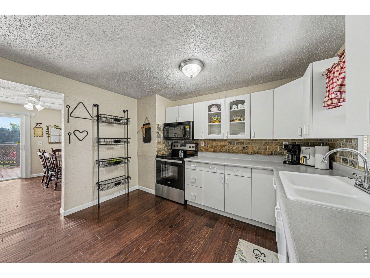 1430 30th Street Road Greeley, CO 80631 - Photo 7 of 22 a kitchen with granite countertop a refrigerator cabinets and wooden floor