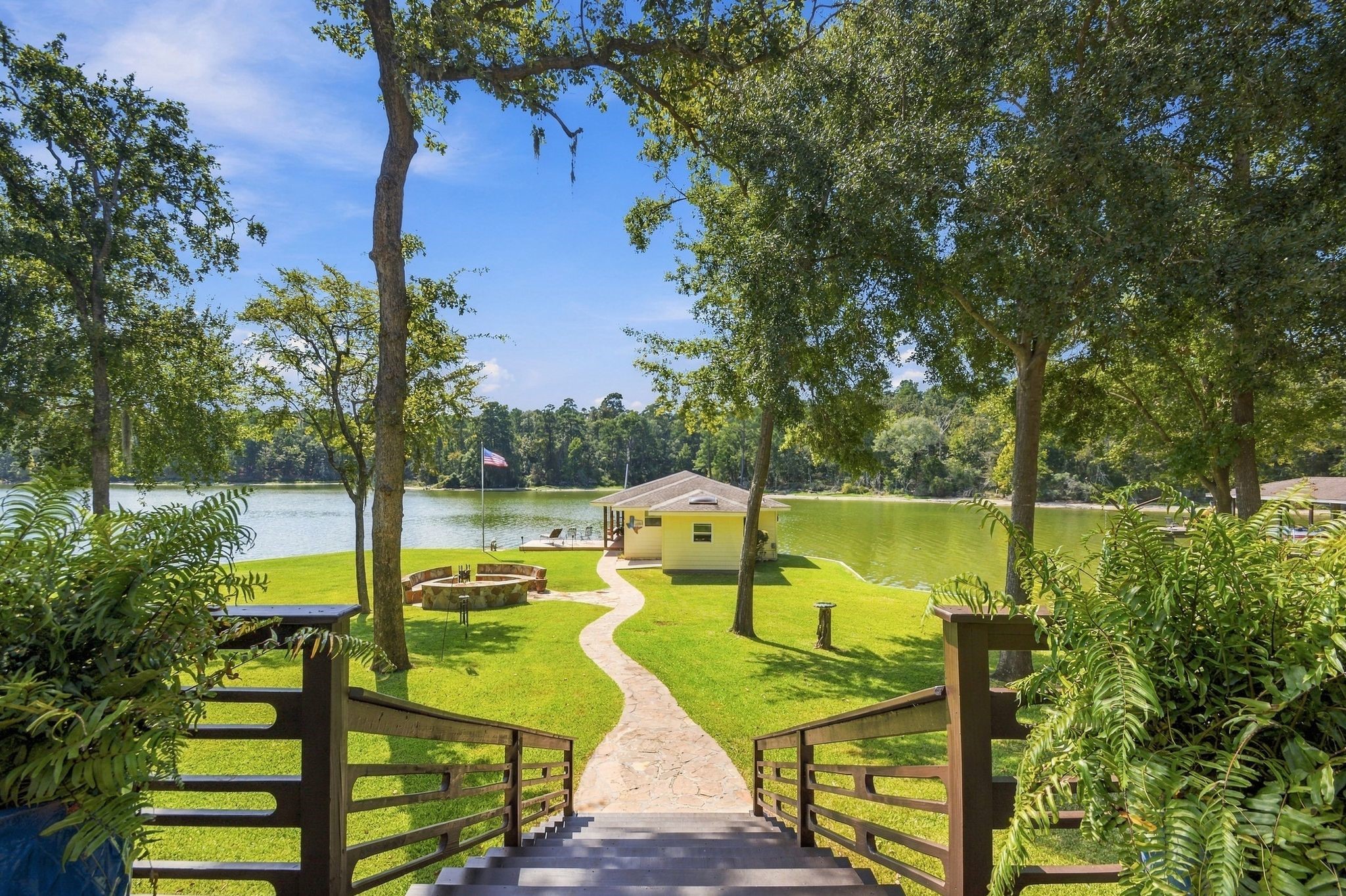 20341 Bay Hill Road Point Blank, TX 77364 - Photo 35 of 50 Experience serene lakeside living with a picturesque path leading to a charming dock, surrounded by lush greenery and tranquil water views.