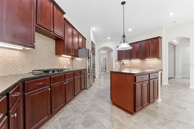 a kitchen with stainless steel appliances granite countertop a stove a sink and a refrigerator