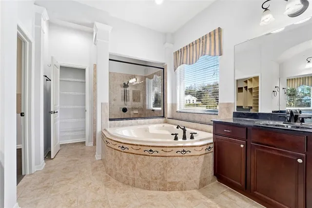 a spacious bathroom with a bathtub sink and mirror