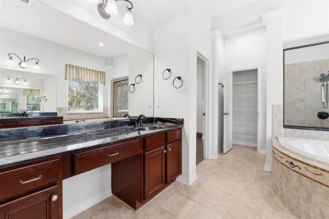 a large kitchen with stainless steel appliances granite countertop a sink and a refrigerator