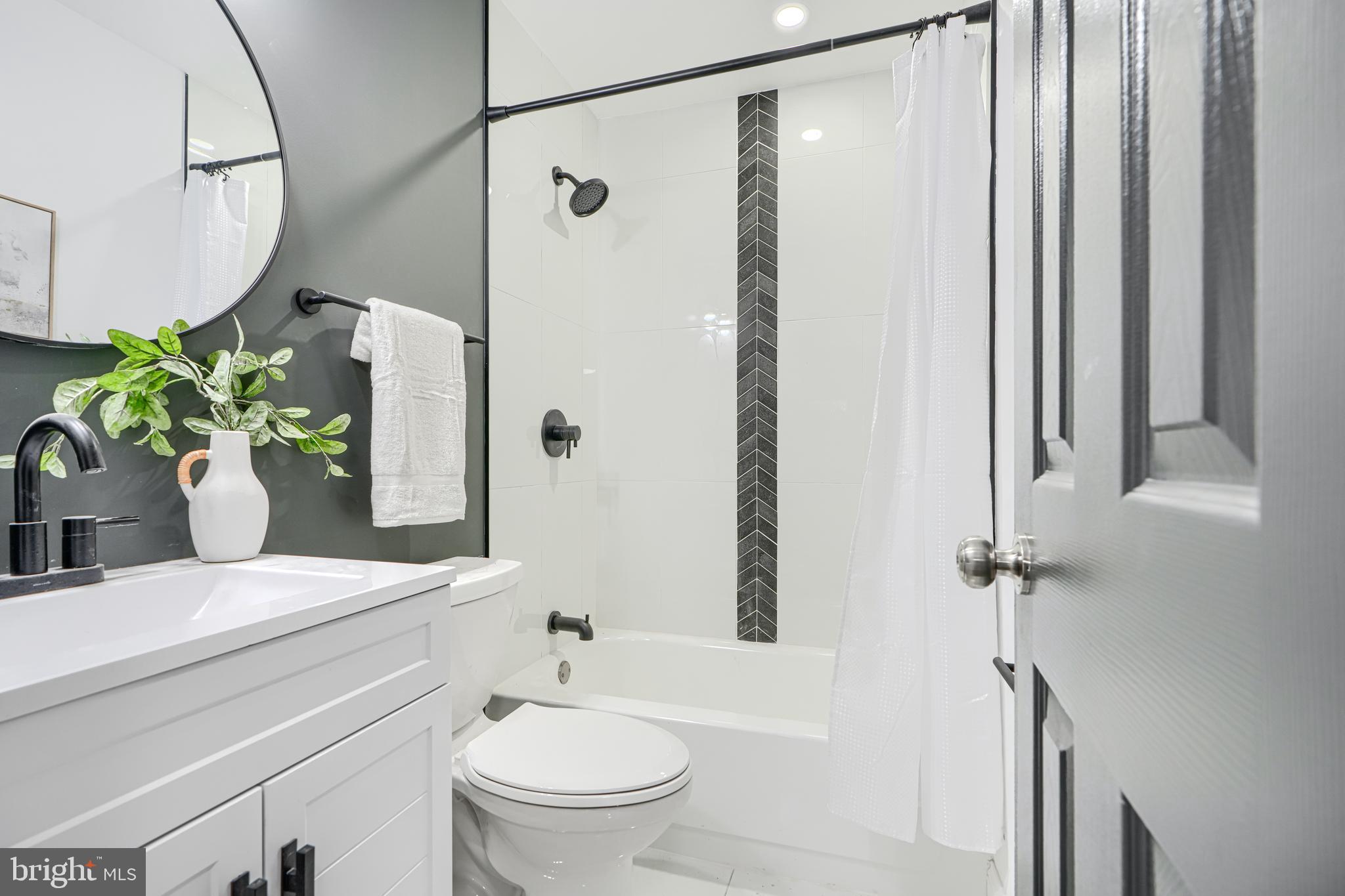718 Benninghaus Road Baltimore, MD 21212 - Photo 21 of 40 a bathroom with a shower a mirror and a toilet