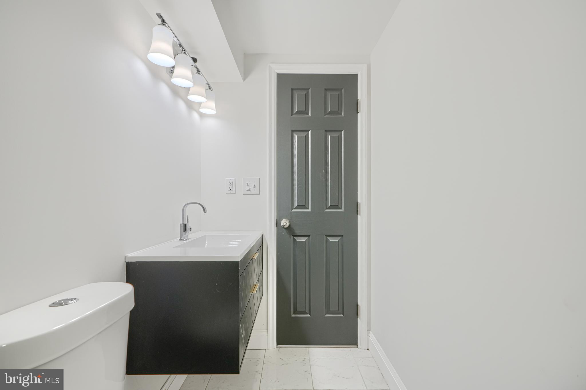 718 Benninghaus Road Baltimore, MD 21212 - Photo 34 of 40 a bathroom with a toilet a sink and mirror