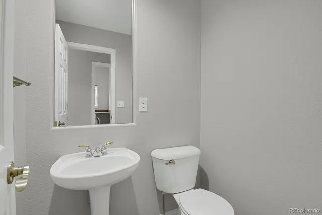 a bathroom with a sink a toilet and mirror