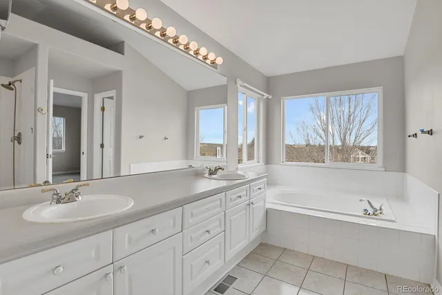 a bathroom with a granite countertop sink mirror and a bathtub