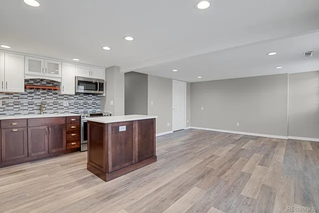 a kitchen with stainless steel appliances granite countertop a stove a sink and a refrigerator