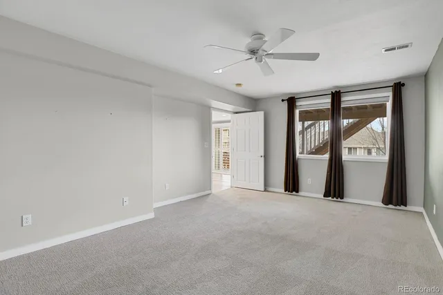a view of a livingroom with a ceiling fan and window